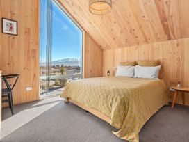 A bedroom with a bed and a window at Peak Perspective - Wanaka Holiday Home Wanaka
