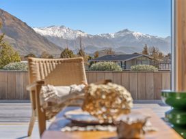 An outdoor space with a chair and a mountain view at Peak Perspective - Wanaka Holiday Home in Wanaka