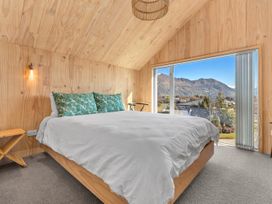 A bedroom with a bed and large window at Peak Perspective - Wanaka Holiday Home Wanaka