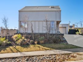 A house with a garage and landscaping at Peak Perspective - Wanaka Holiday Home, Wanaka