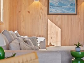 A living room with a sofa and cushions at Peak Perspective - Wanaka Holiday Home in Wanaka