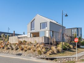 A house with a slanted roof and large windows at Peak Perspective - Wanaka Holiday Home, Wanaka
