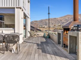 An outdoor deck with a table and chairs at Peak Perspective - Wanaka Holiday Home Wanaka