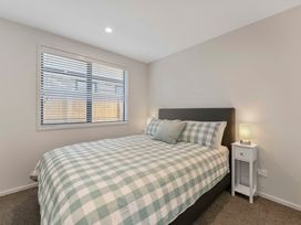 A bedroom with a bed and bedside table at The Cozy Koha - Taupo Holiday Home Taupo