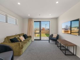 A living room with a sofa and a TV at The Cozy Koha - Taupo Holiday Home, Taupo