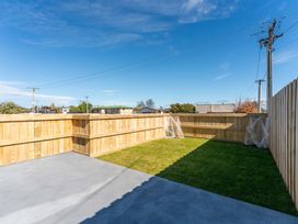 A garden area with grass and a wooden fence at The Cozy Koha - Taupo Holiday Home, Taupo