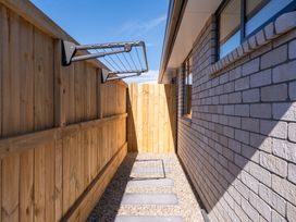 An outdoor area with a fence and clothesline at The Cozy Koha - Taupo Holiday Home in Taupo
