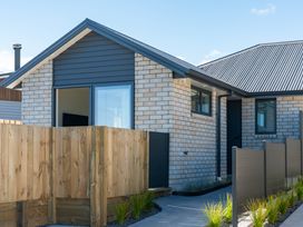 An exterior view of a house with a pathway and fence at The Cozy Koha - Taupo Holiday Home in Taupo