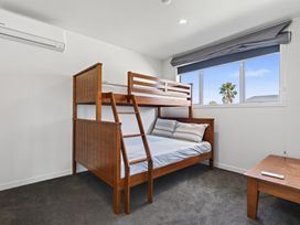 A bedroom with a bunk bed and a window at Starling - Mangawhai Heads Holiday Home Mangawhai Heads