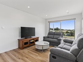 A living room with a television and sofa at Starling - Mangawhai Heads Holiday Home, Mangawhai Heads