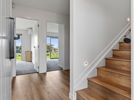 A hallway with stairs and doors at Starling - Mangawhai Heads Holiday Home Mangawhai Heads