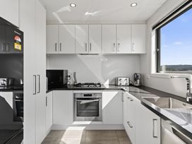 A kitchen with an oven and sink at Starling - Mangawhai Heads Holiday Home in Mangawhai Heads