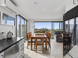 A kitchen and dining area with a table and chairs at Starling - Mangawhai Heads Holiday Home Mangawhai Heads