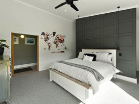 A bedroom with a bed and wall art at The Black Barn - Whakatane Holiday Home, Whakatane