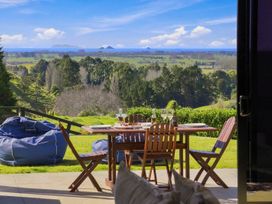 An outdoor dining area with a table and chairs at The Black Barn - Whakatane Holiday Home Whakatane