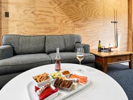 A living room with a sofa and a snack platter at The Black Barn - Whakatane