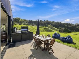 An outdoor dining area with a barbecue and table at The Black Barn - Whakatane Holiday Home Whakatane