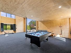 A game room with a pool table and seating at The Black Barn - Whakatane Holiday Home in Whakatane
