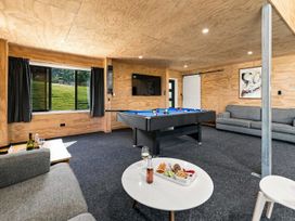 A snug with a pool table and sofa at The Black Barn - Whakatane Holiday Home in Whakatane