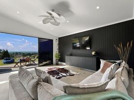 A living room with a TV and sofa at The Black Barn - Whakatane Holiday Home Whakatane