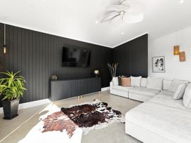 A living room featuring a sofa and television at The Black Barn - Whakatane Holiday Home in Whakatane