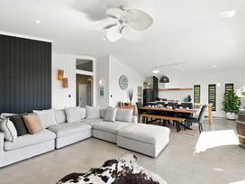 A living room with a sofa and dining area at The Black Barn - Whakatane Holiday Home Whakatane