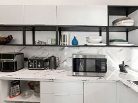 A kitchen with appliances and tableware at The Black Barn - Whakatane Holiday Home Whakatane