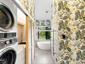 A bathroom with a washing machine and dryer at The Black Barn - Whakatane