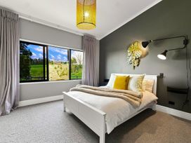 A bedroom with a bed and window at The Black Barn - Whakatane Holiday Home, Whakatane