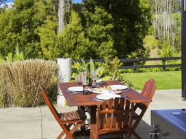 An outdoor dining area with a table set for a meal at The Black Barn - Whakatane