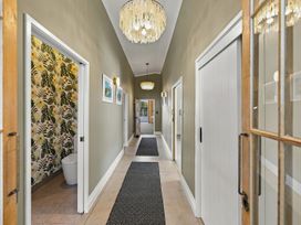 A hallway with a toilet and wall art at The Black Barn - Whakatane Holiday Home Whakatane