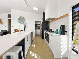 A kitchen with a sink and stove at The Black Barn - Whakatane Holiday Home Whakatane