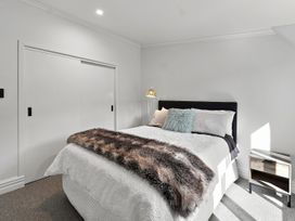 A bedroom with a bed and nightstand at The Black Barn - Whakatane Holiday Home in Whakatane