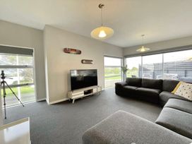 A living room with a sofa and television at Vinnie’s haven - Opunake Holiday Home