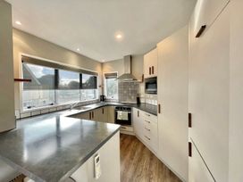A kitchen with countertop, oven, and sink at Vinnie’s haven - Opunake Holiday Home