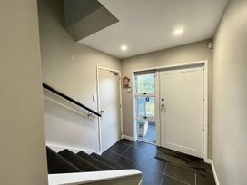 An entrance with a staircase, door, and window at Vinnie's haven - Opunake Holiday Home
