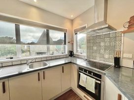 A kitchen with sink and stove at Vinnie’s haven - Opunake Holiday Home