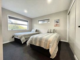 A bedroom with two beds and a window at Vinnie’s haven - Opunake Holiday Home