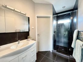 A bathroom with a shower and washbasin at Vinnie’s haven - Opunake Holiday Home