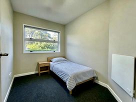 A bedroom with a bed and nightstand at Vinnies Haven - Opunake Holiday Home, Taranaki