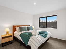 A bedroom with a bed and bedside lamp at Hosking Haven - Cromwell