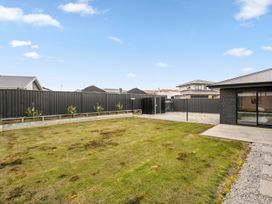 A garden space with grass and a fence at Hosking Haven - Cromwell