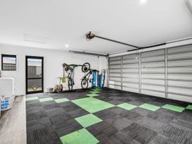 A garage with bicycles mounted on the wall and a washing machine at Hosking Haven - Cromwell