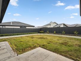 A garden with grass and a fenced area at Hosking Haven - Cromwell Holiday Home, Cromwell