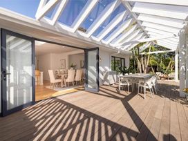 An outdoor patio with dining table and chairs at Poolside on Moffat - Tauranga