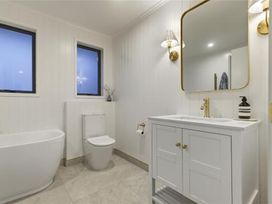A bathroom with a bathtub and sink at Poolside on Moffat - Tauranga Holiday Home Tauranga