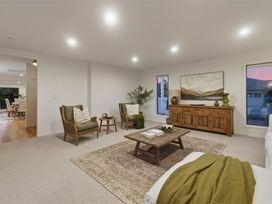 A living room with armchairs and a coffee table at Poolside on Moffat - Tauranga