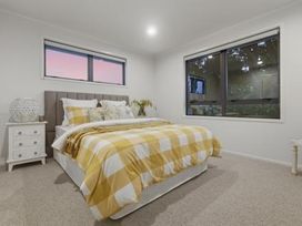 A bedroom with a bed and bedside table at Poolside on Moffat - Tauranga Holiday Home, Tauranga