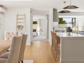 A dining room with a table and chairs at Poolside on Moffat in Tauranga