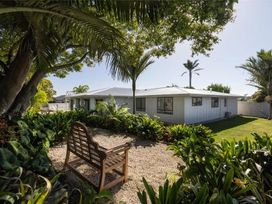 A garden with a bench and plants at Poolside on Moffat - Tauranga
